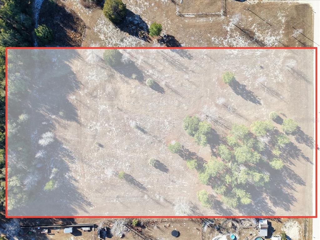 An aerial view shows a rectangular plot of land with scattered trees and grass — NW 76TH AVENUE, CHIEFLAND, FL