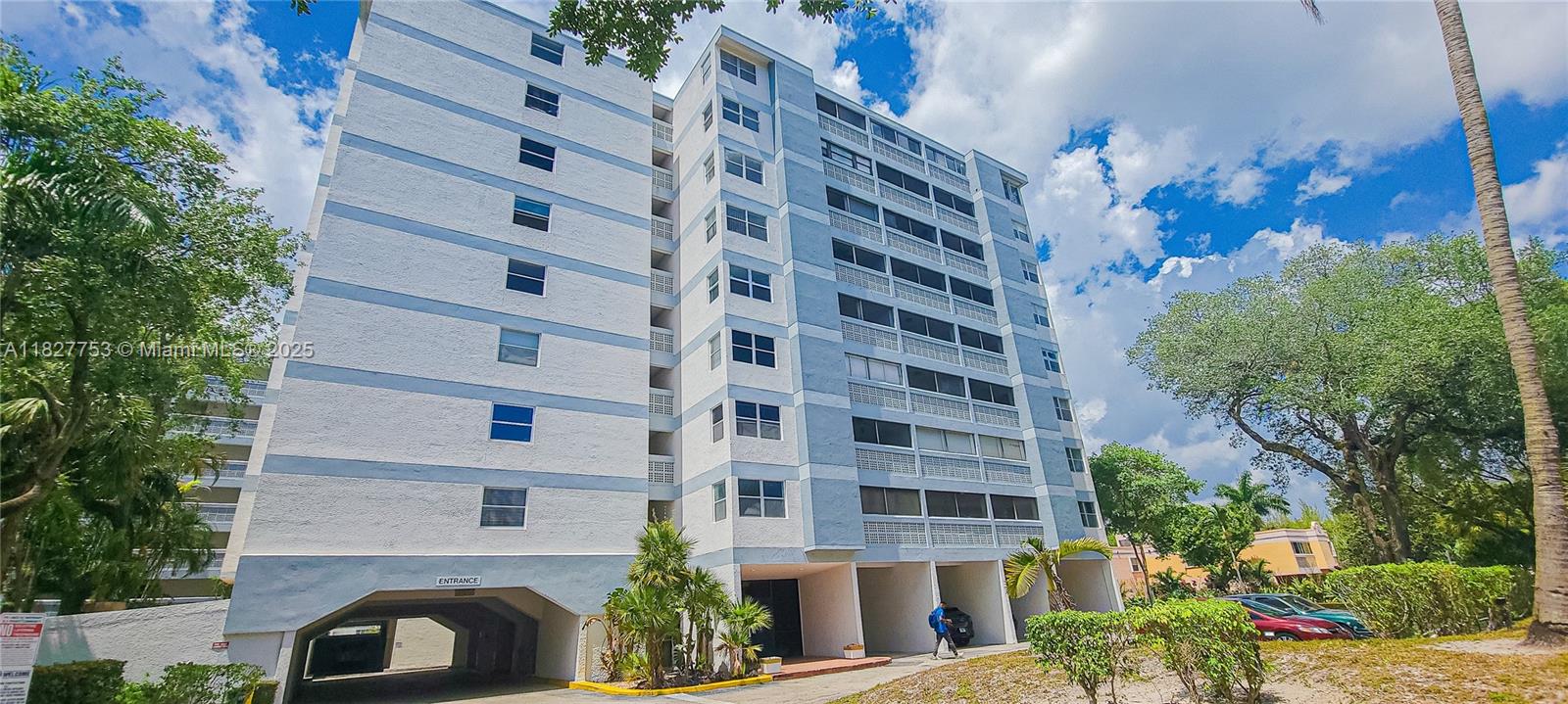 A multi-story residential apartment building with a ground-level parking entrance and surrounding landscaping — 3301 Spanish Moss Ter # 609, Lauderhill FL 33319, LAUDERHILL, FL