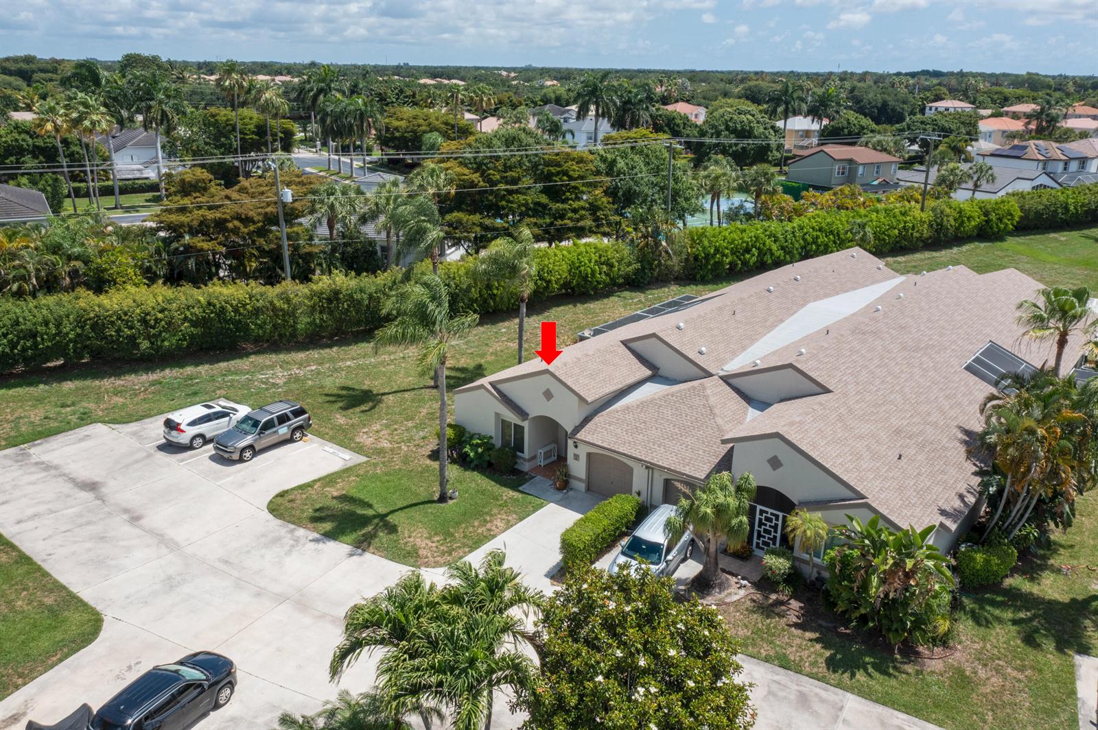 An aerial view shows a residential building with a shingled roof and a paved driveway — 9497 Boca Gardens Parkway # A, Boca Raton FL 33496, BOCA RATON, FL