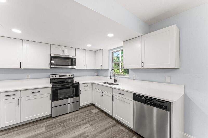 A kitchen features white cabinets, stainless steel appliances, and light-colored countertops — 11852 N 47th Rd Road N, FL 33411, FL