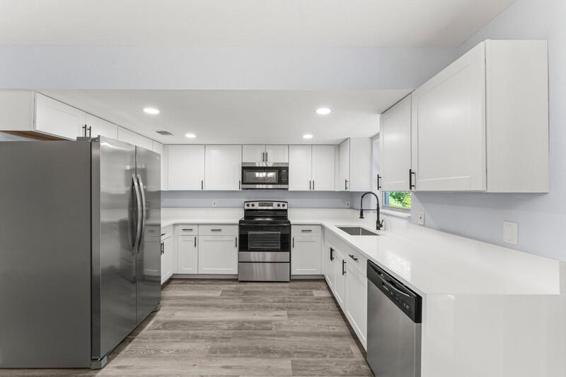 A modern kitchen features white cabinets, stainless steel appliances, and light-colored countertops — 11852 N 47th Rd Road N, FL 33411, FL