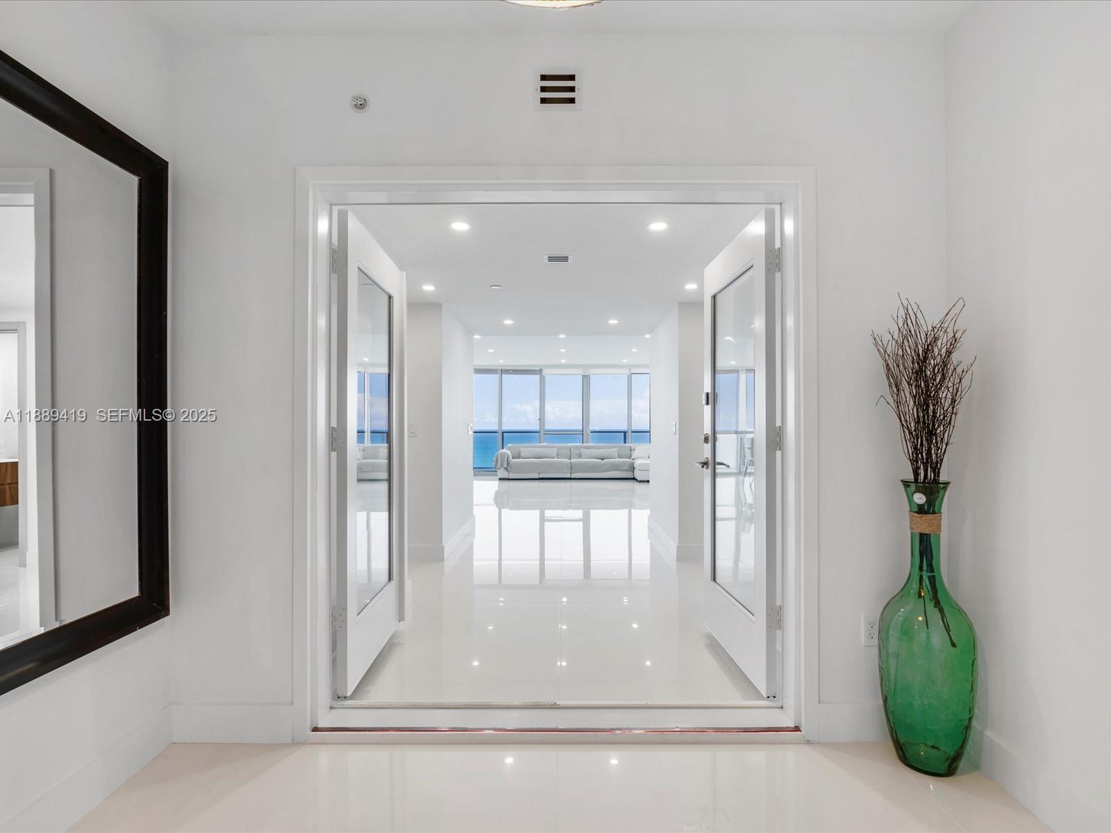 A bright entryway with white tile floors leads through double doors to an oceanfront living area — 3101 S Ocean Dr # 1608, Hollywood FL 33019, HOLLYWOOD, FL