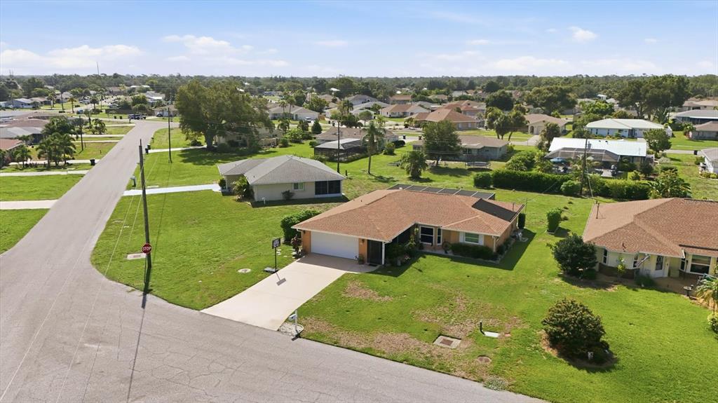An aerial view of a suburban neighborhood featuring single-story houses with brown shingled roofs — 911 GASPARILLA BOULEVARD, ENGLEWOOD, FL