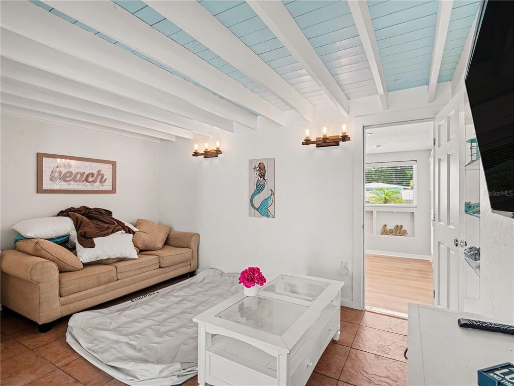 A living room features a beige sofa, an air mattress, and a white coffee table — 2547 BAHIA VISTA STREET, SARASOTA, FL