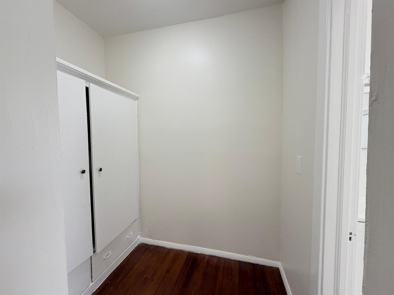 A small room with white walls, dark wood flooring, and a built-in white wardrobe — 623 Park Place Unit 5, West Palm Beach FL 33401, WEST PALM BEACH, FL
