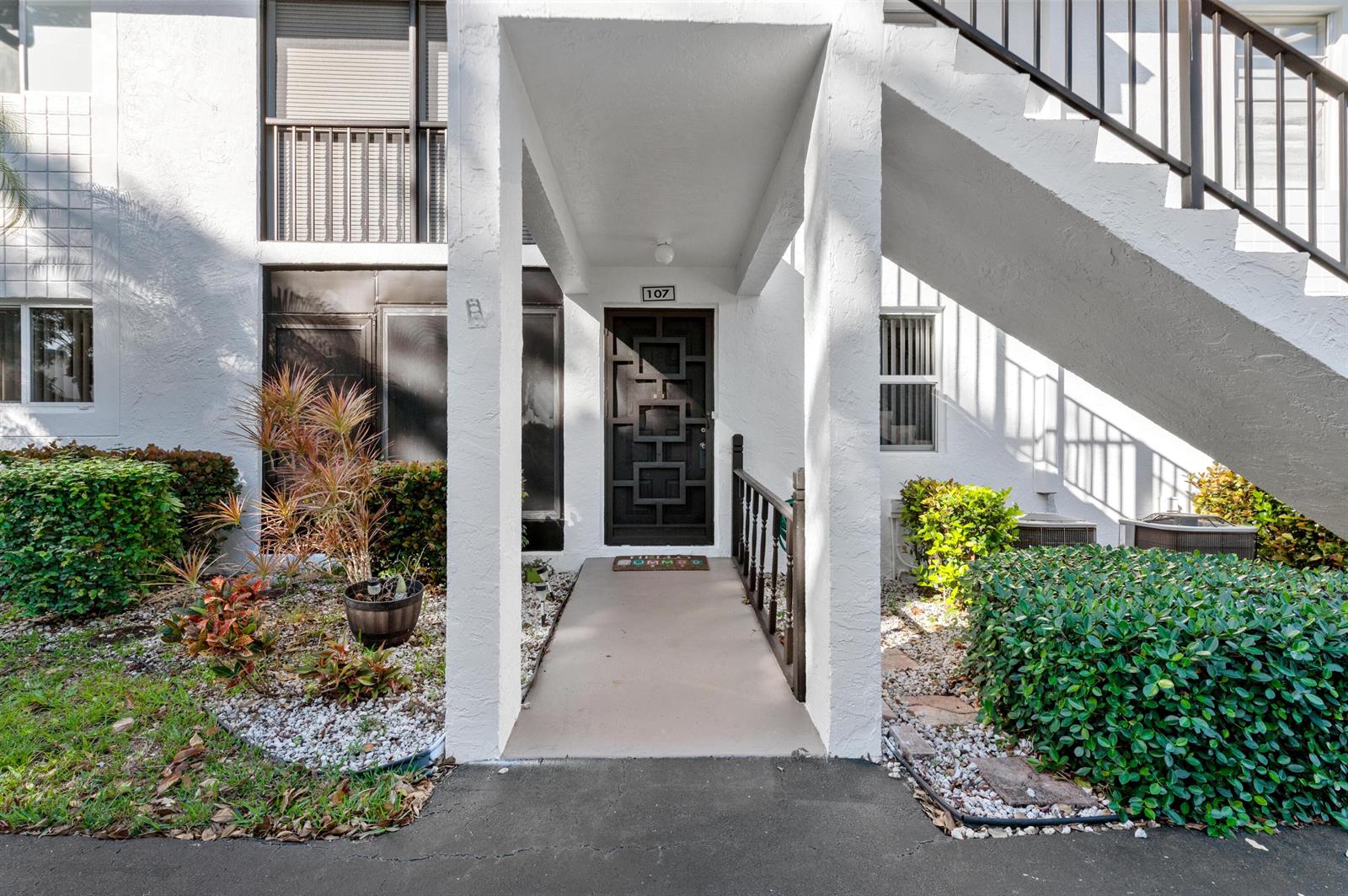An open-concept living and dining area features large gray floor tiles and a kitchen — 14895 Builtmore Way # 107, Delray Beach FL 33446, DELRAY BEACH, FL