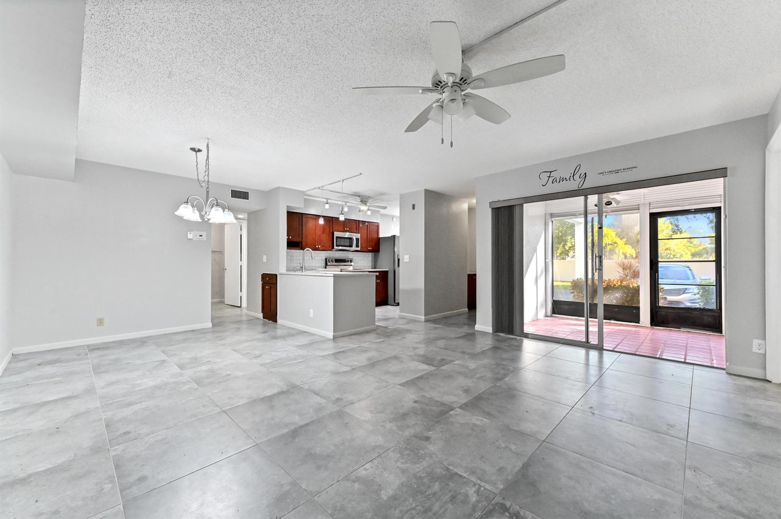A kitchen with dark wood cabinets, stainless steel appliances, and gray tile flooring — 14895 Builtmore Way # 107, Delray Beach FL 33446, DELRAY BEACH, FL