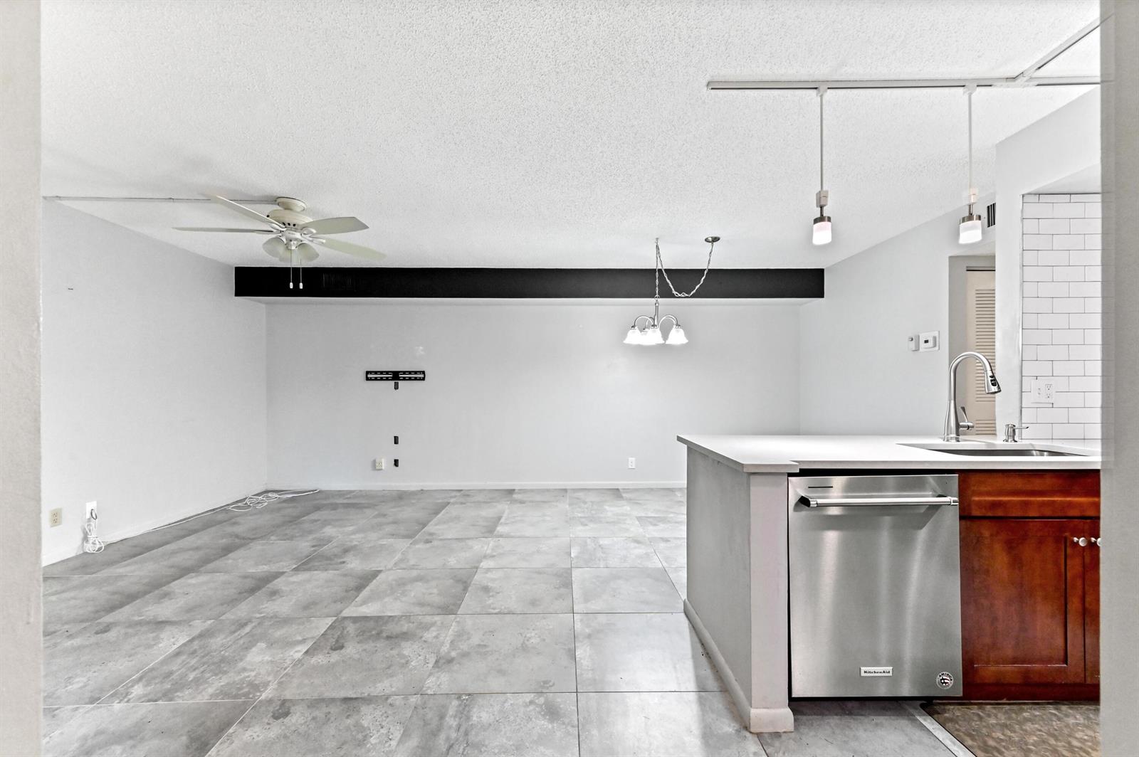 A kitchen with a stainless steel dishwasher and a large, open-concept living area with tile — 14895 Builtmore Way # 107, Delray Beach FL 33446, DELRAY BEACH, FL