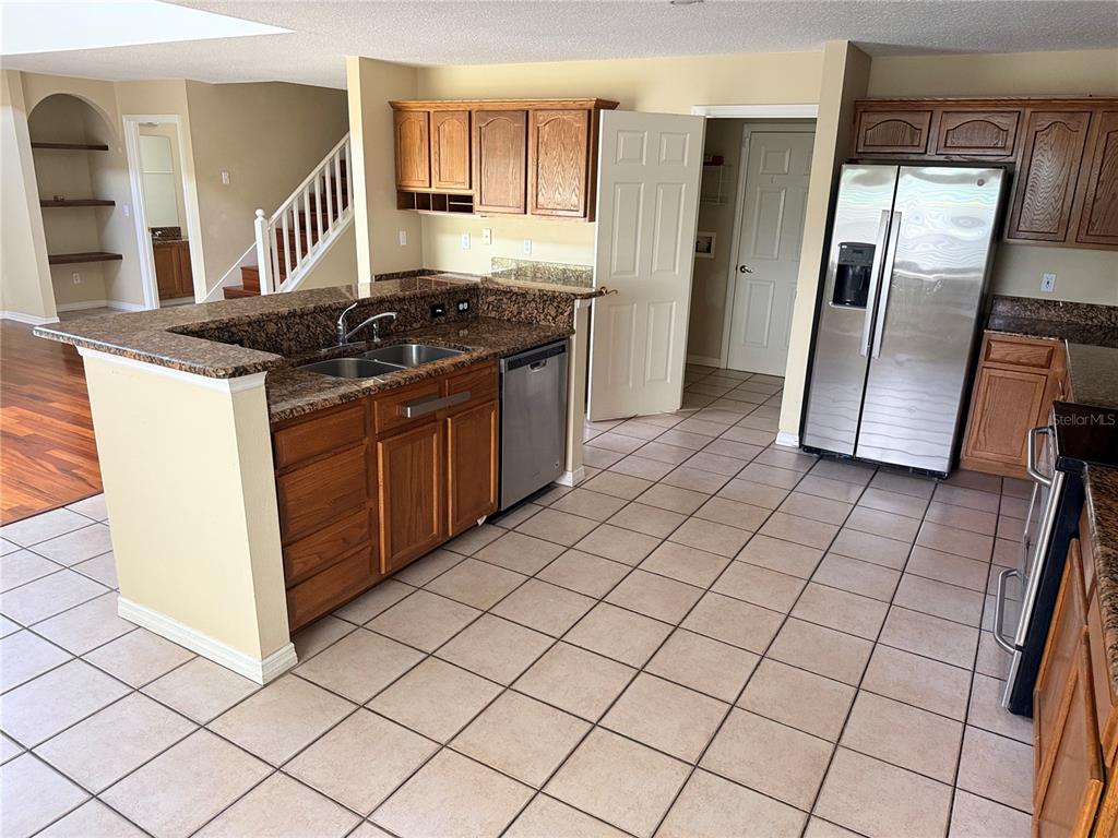 A kitchen with wood cabinets, granite countertops, stainless steel appliances, and tiled flooring — 443 OPAL COURT, ALTAMONTE SPRINGS, FL