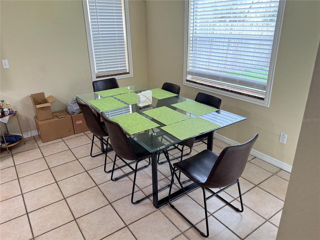A dining area features a glass-topped table with six chairs on a tiled floor — 443 OPAL COURT, ALTAMONTE SPRINGS, FL