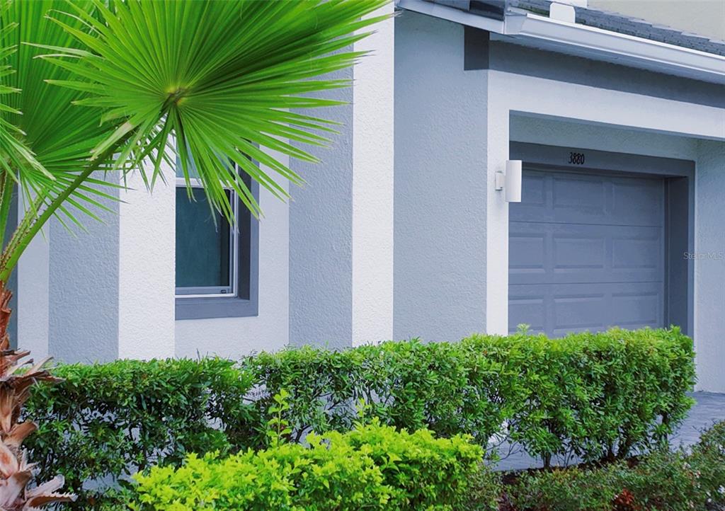 A gray garage door and a window are visible on the exterior of a house — 3880 SONOMA BOULEVARD, KISSIMMEE, FL