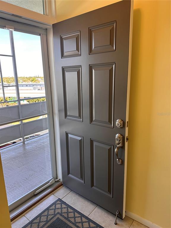 A gray six-panel front door opens onto a balcony with a view of buildings — 5900 SHORE BOULEVARD S UNIT 504, GULFPORT, FL