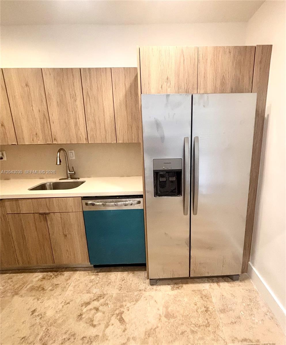 A kitchen features light wood cabinets, a stainless steel refrigerator, and a blue dishwasher — 2666 Tigertail Ave # 114, Miami FL 33133, MIAMI, FL