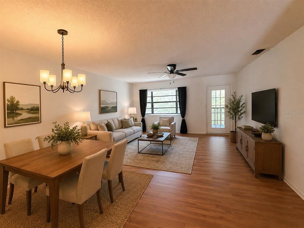 A living and dining room with wood-look flooring, a ceiling fan, and a chandelier — 12155 ENVIRONMENTAL DRIVE UNIT 6, NEW PORT RICHEY, FL