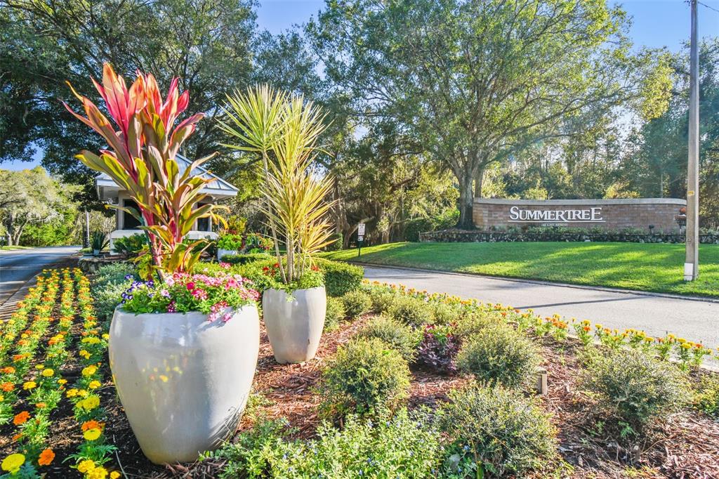 A brick monument sign for Summertree stands behind large potted plants and landscaped flower beds — 12154 PUTTER GREEN COURT, NEW PORT RICHEY, FL