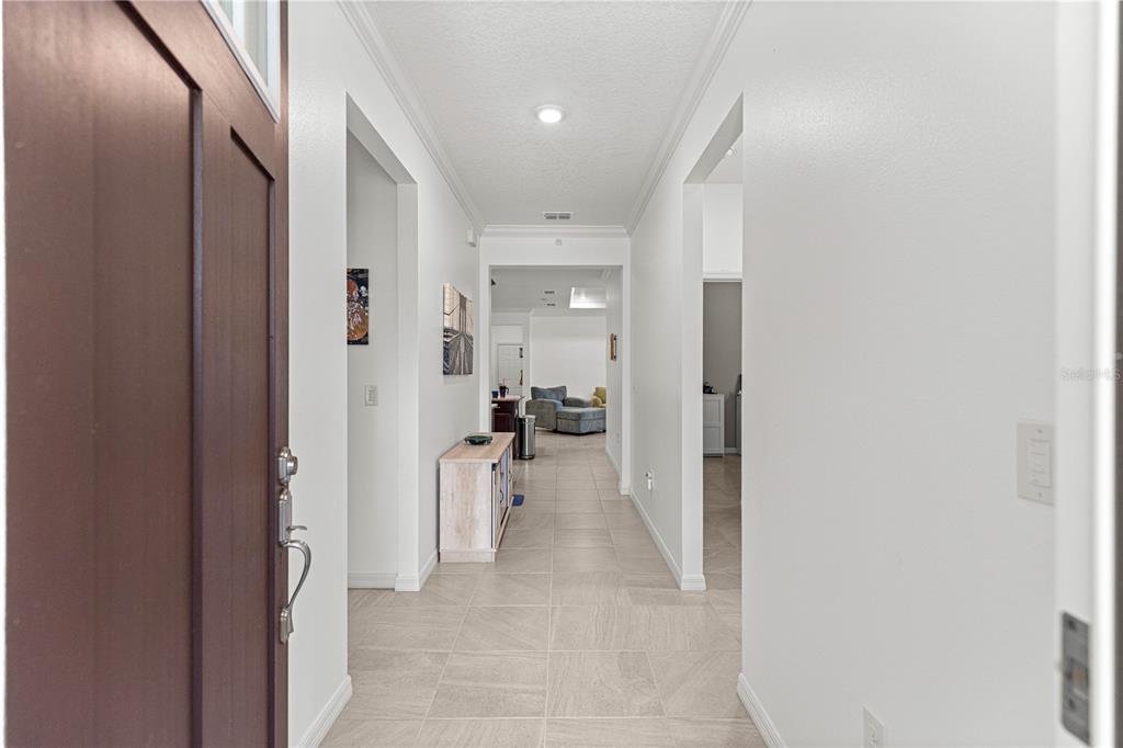 A view from a front doorway looking down a tiled hallway into an open living area — 8952 SW 78TH COURT, OCALA, FL