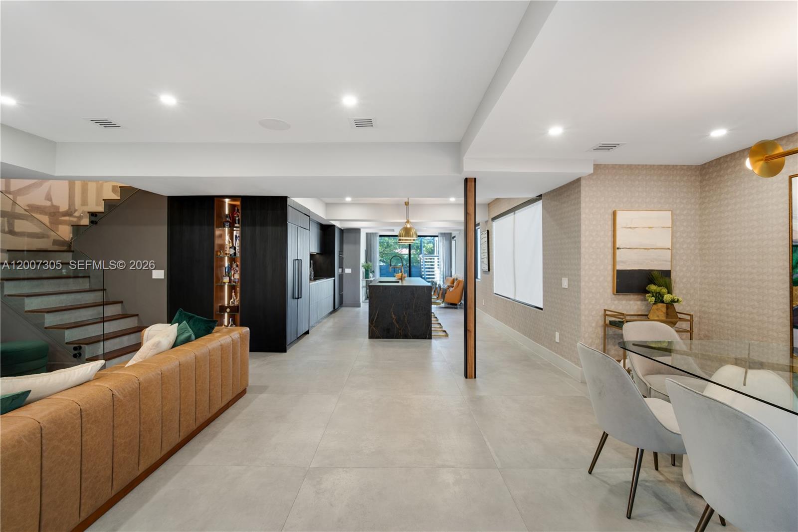 An open-concept living and dining area features a modern kitchen with a dark stone island — 145 NE 49th St # A, Miami FL 33137, MIAMI, FL