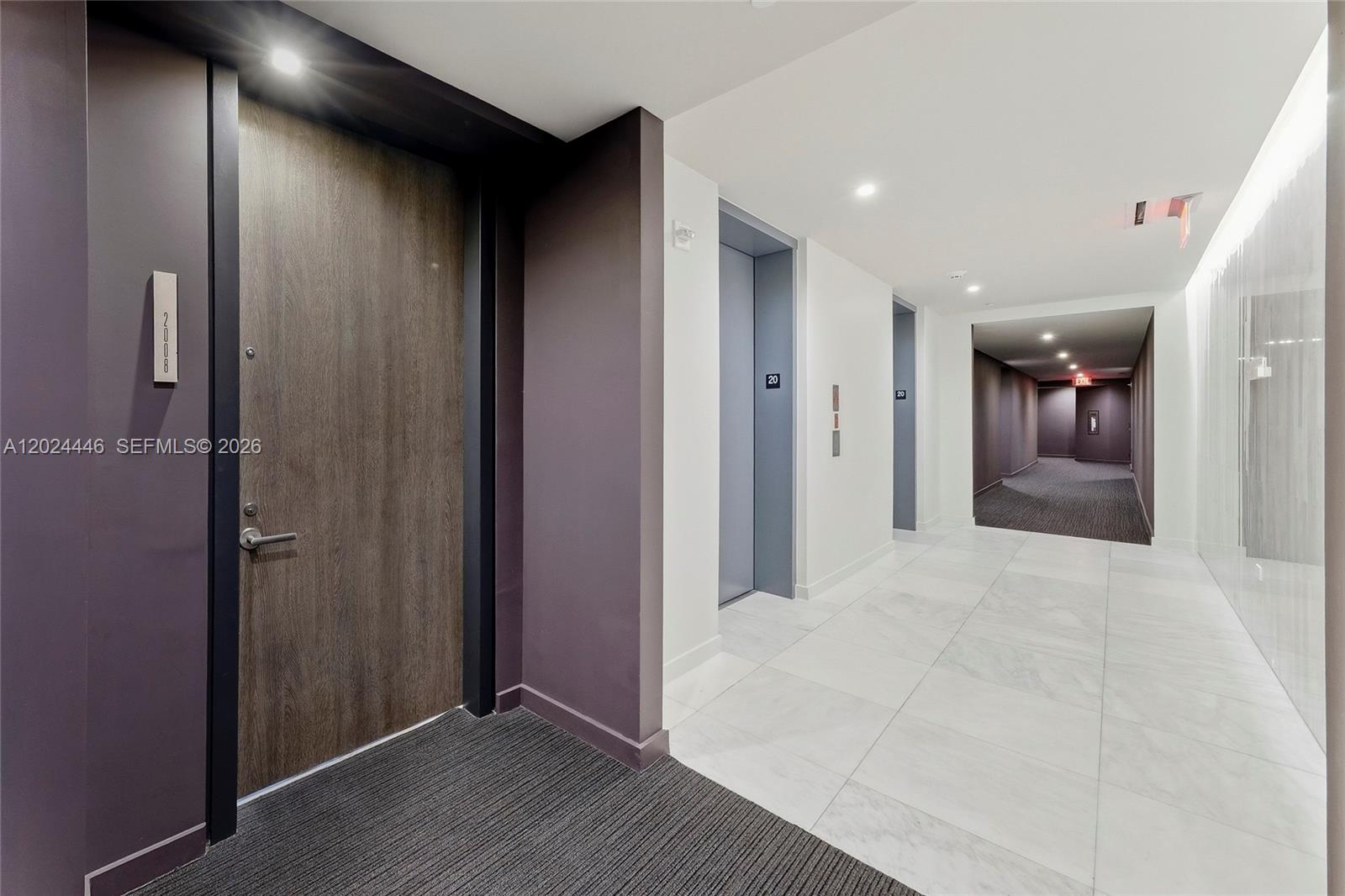 A hallway features a wood-grain door, elevator access, white tiled flooring, and recessed lighting — 88 SW 7th St # 2008, Miami FL 33130, MIAMI, FL