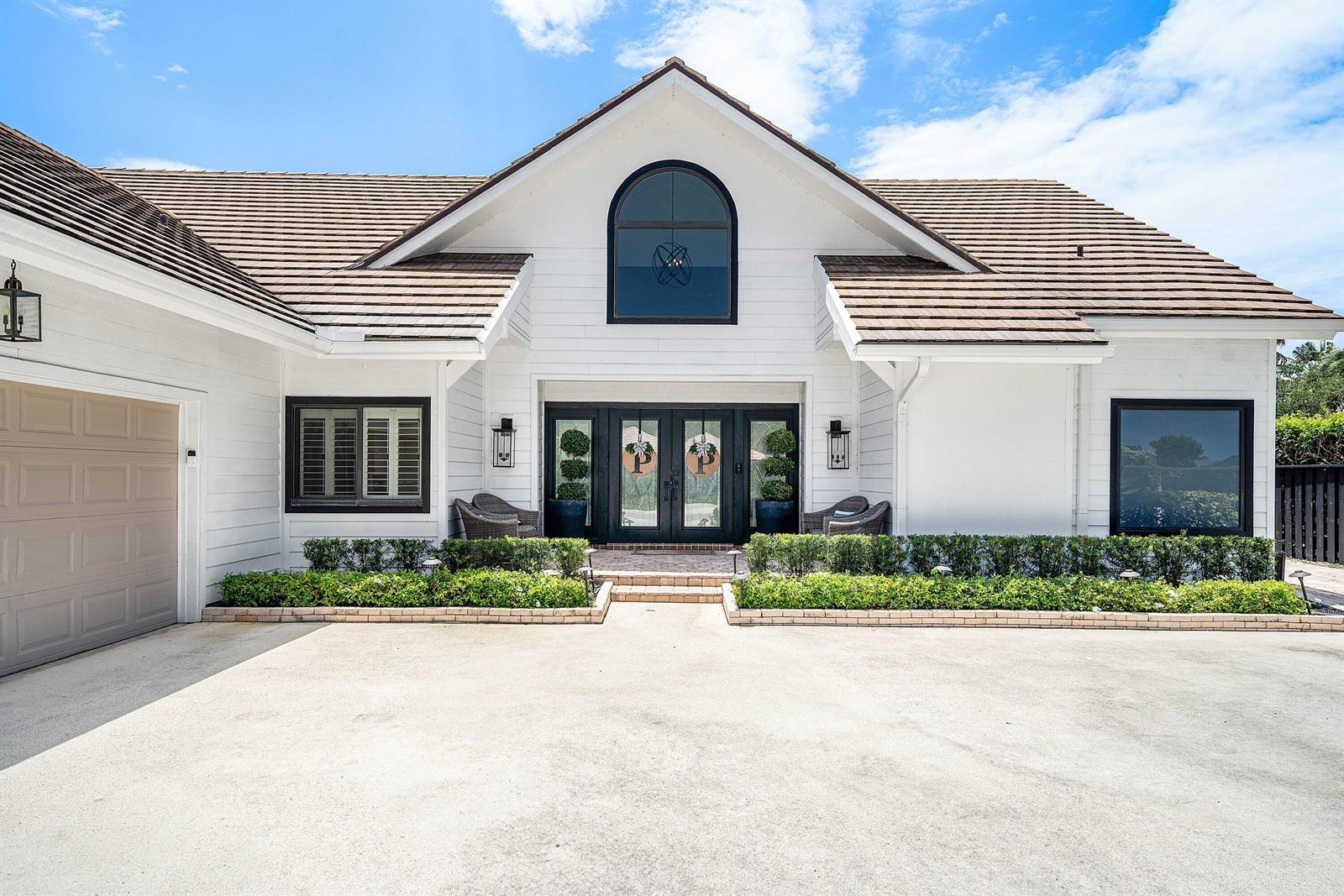 A white house with a brown tile roof, black window frames, and a double front door — 2707 Biarritz Drive, Palm Beach Gardens FL 33410, PALM BEACH GARDENS, FL