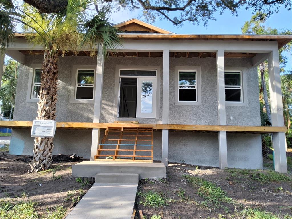 A raised house with a front porch, wooden stairs, and a concrete walkway — 383 GEORGIA AVENUE, CRYSTAL BEACH, FL