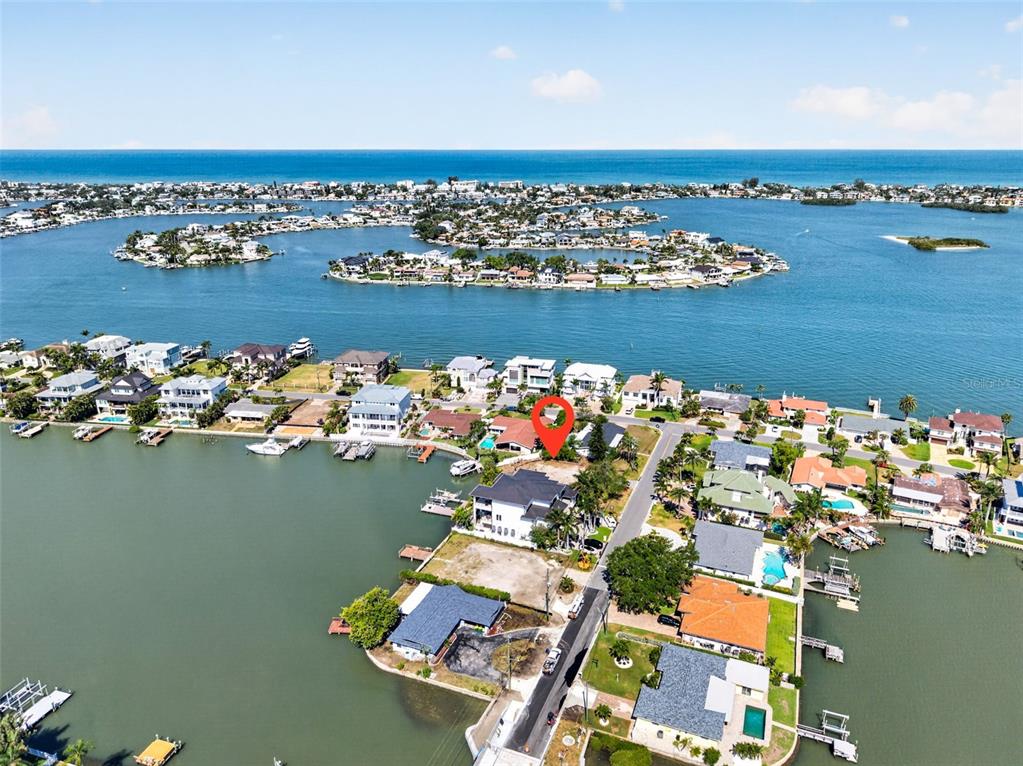 An aerial view shows a waterfront residential lot marked with a red pin — 909 OAKWOOD DRIVE, LARGO, FL