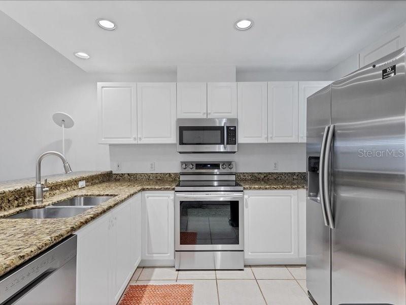 A kitchen with white cabinets, stainless steel appliances, and granite countertops — 3706 54TH DRIVE W UNIT 103, BRADENTON, FL
