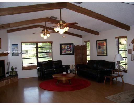 A living room features vaulted ceilings with exposed wood beams, two ceiling fans, and furniture — 11520 NW 26th St, Plantation FL 33323, PLANTATION, FL
