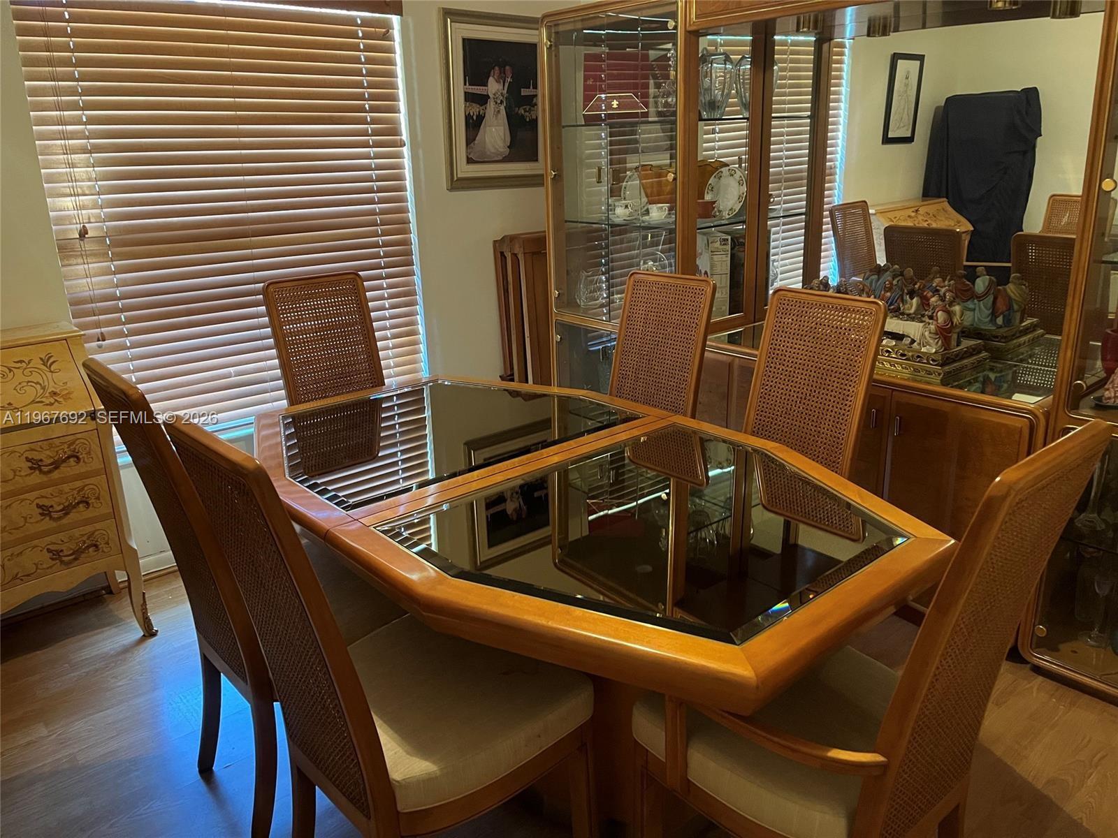 A dining room features a wooden table with mirrored insets and six cane-back chairs — 11520 NW 26th St, Plantation FL 33323, PLANTATION, FL