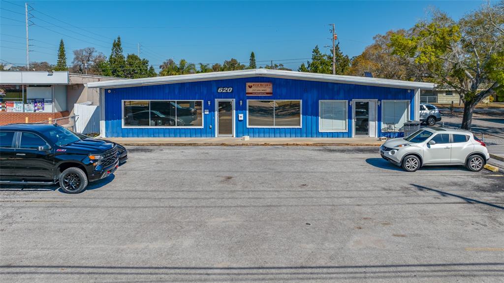 A blue commercial building with a parking lot in front and two parked cars — 620 UNION STREET, DUNEDIN, FL