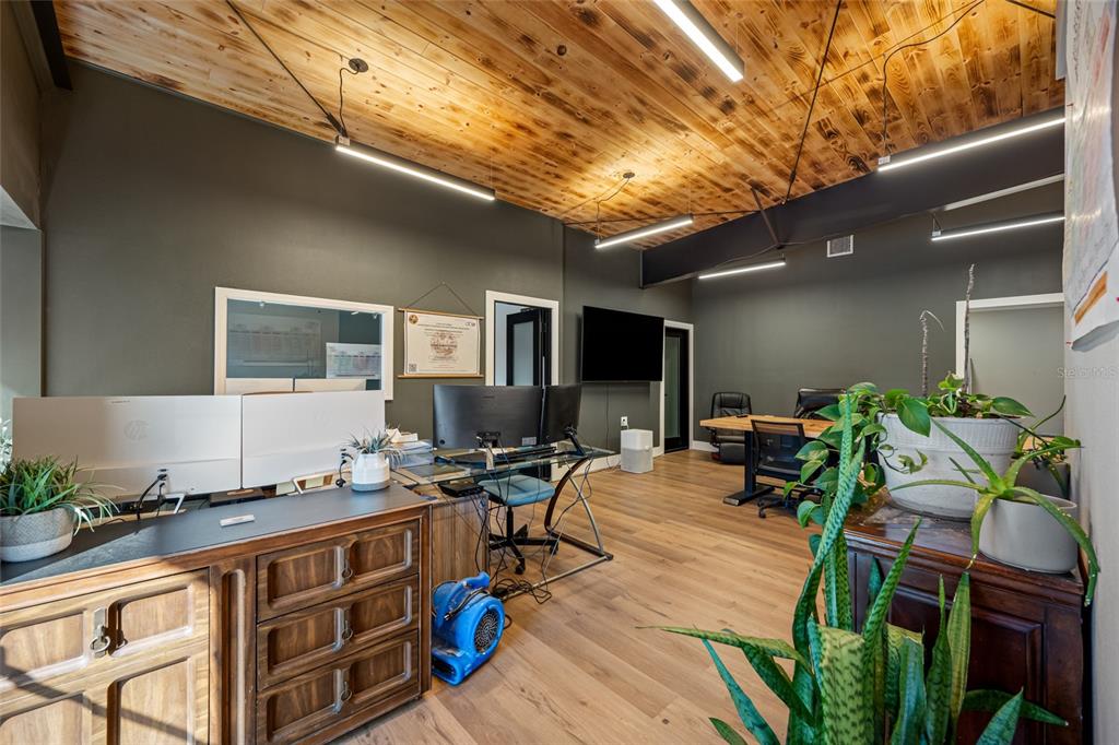 An office space features a wood-paneled ceiling, dark walls, and multiple desks with computers — 620 UNION STREET, DUNEDIN, FL
