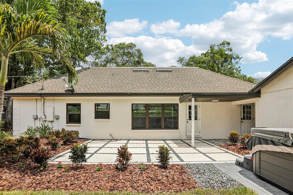 The exterior of a house features a paved patio, a covered entryway, and a hot tub — 4708 W NEPTUNE STREET, TAMPA, FL