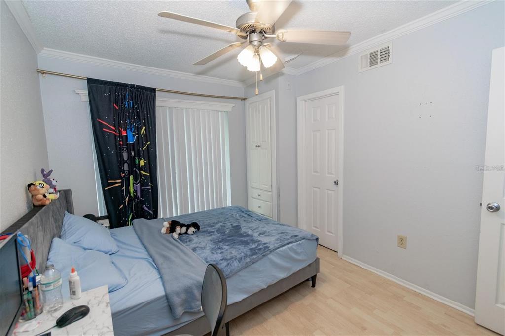 A bedroom features a bed with blue bedding, a ceiling fan, and light-colored flooring — 139 OYSTER BAY CIRCLE UNIT 200, ALTAMONTE SPRINGS, FL