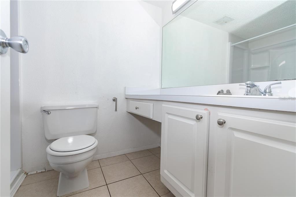 A bathroom features a white toilet, a vanity with a sink, and a large mirror — 139 OYSTER BAY CIRCLE UNIT 200, ALTAMONTE SPRINGS, FL