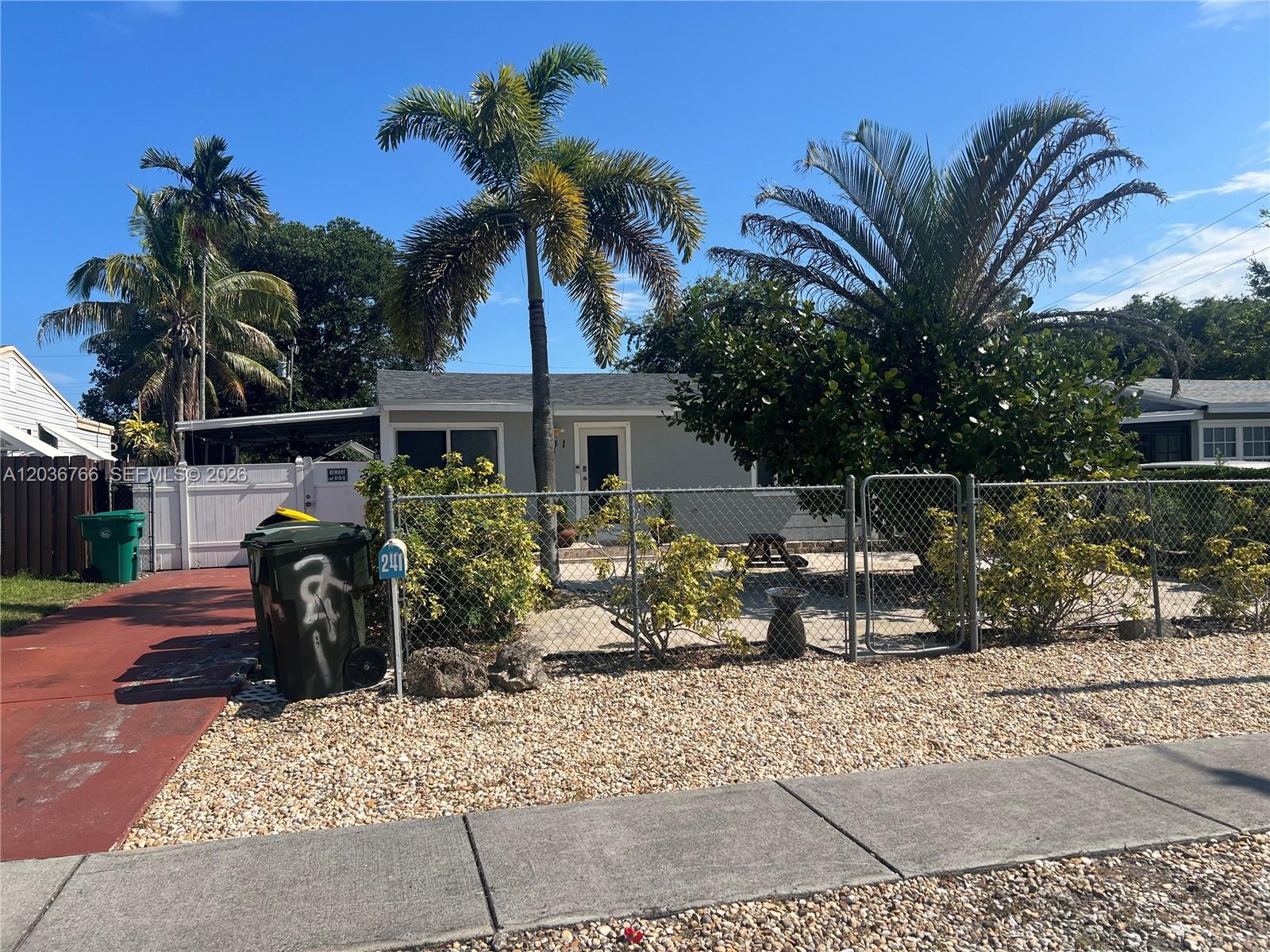 A single-story house with a chain-link fence, palm trees, and a gravel front yard — 241 SW 3rd Ter # 0, Dania Beach FL 33004, DANIA BEACH, FL