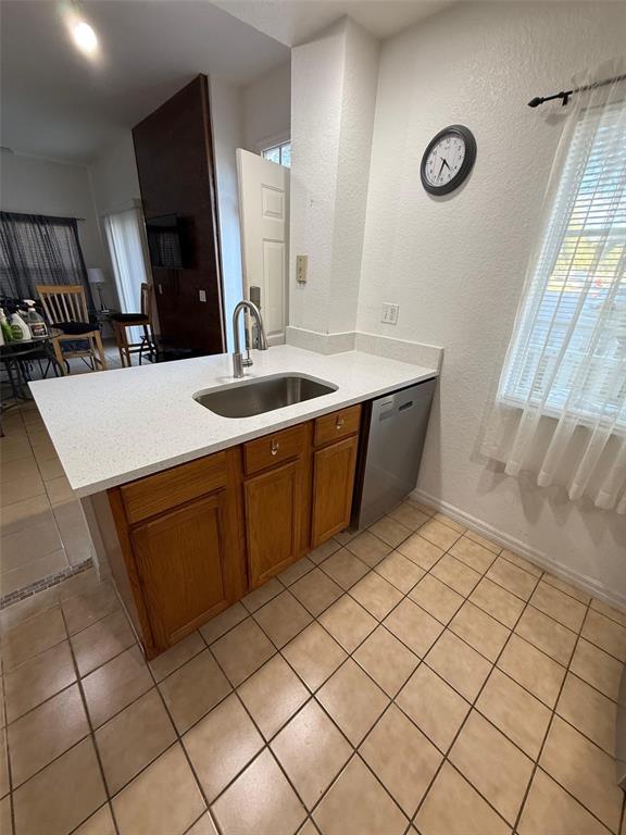 A kitchen area features a white countertop, stainless steel sink, and wood cabinets — 2250 SAN VITAL DRIVE UNIT 107, KISSIMMEE, FL