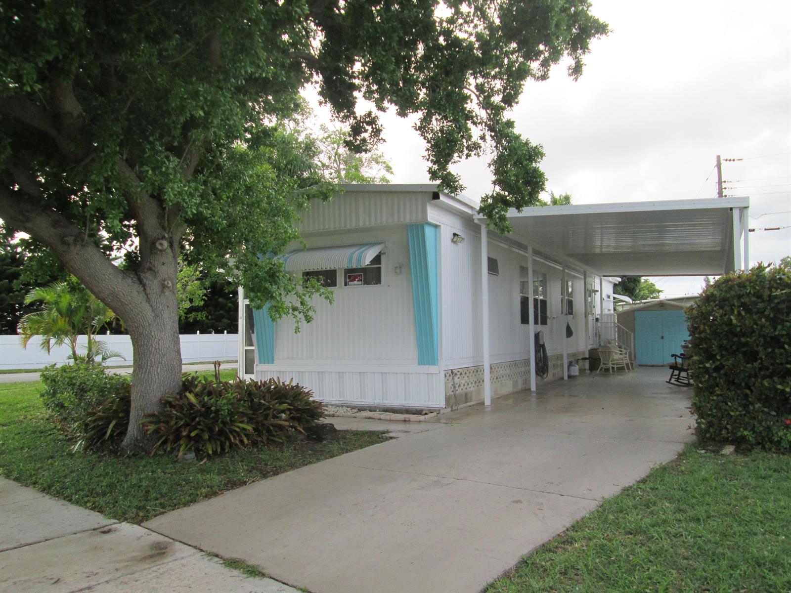 A white mobile home with a carport, a large tree, and a concrete driveway — 4261 Meadow View Drive, Boynton Beach FL 33436, BOYNTON BEACH, FL