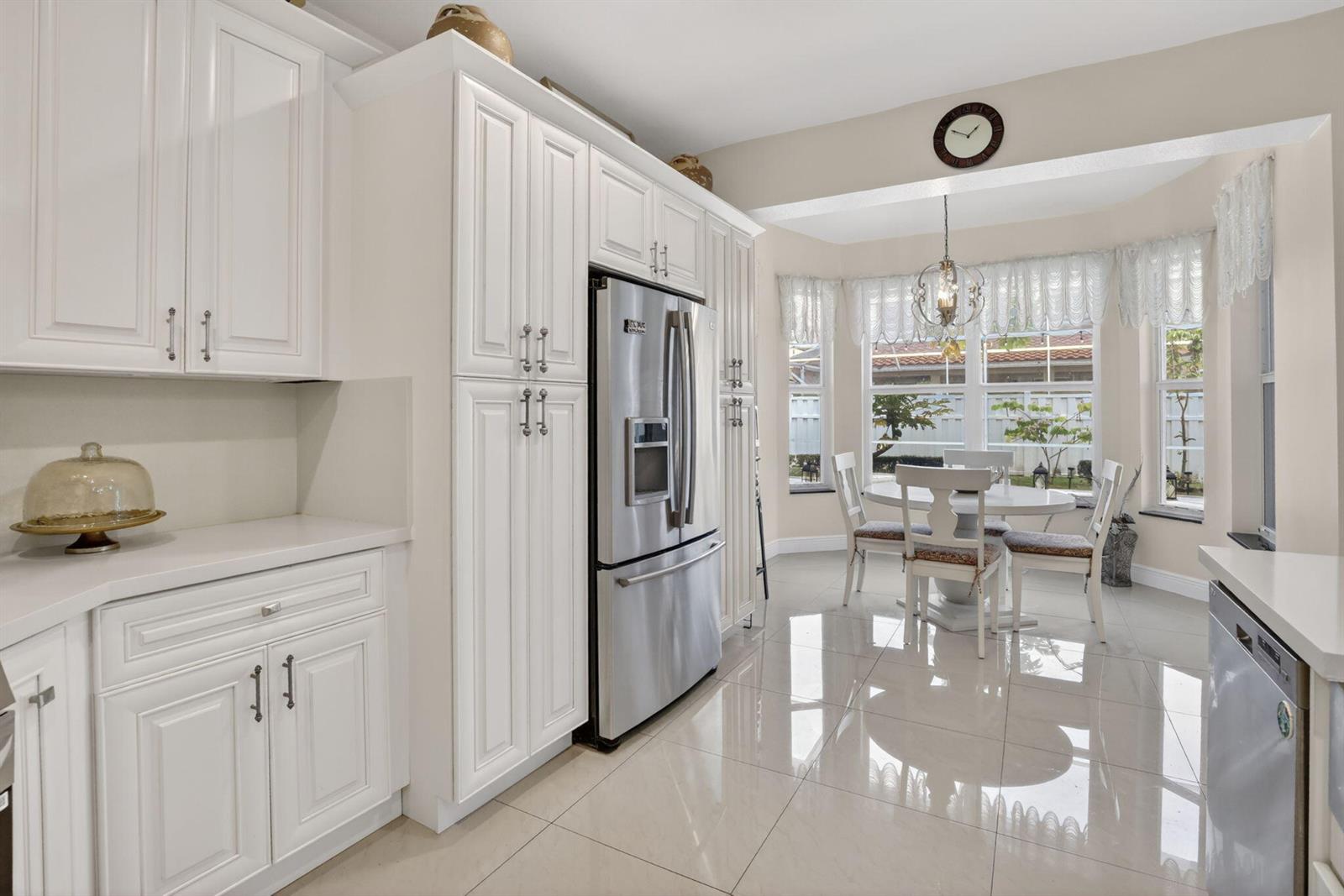 A kitchen with white cabinets, stainless steel appliances, and a breakfast nook with bay windows — 711 Heritage Way, Weston FL 33326, WESTON, FL