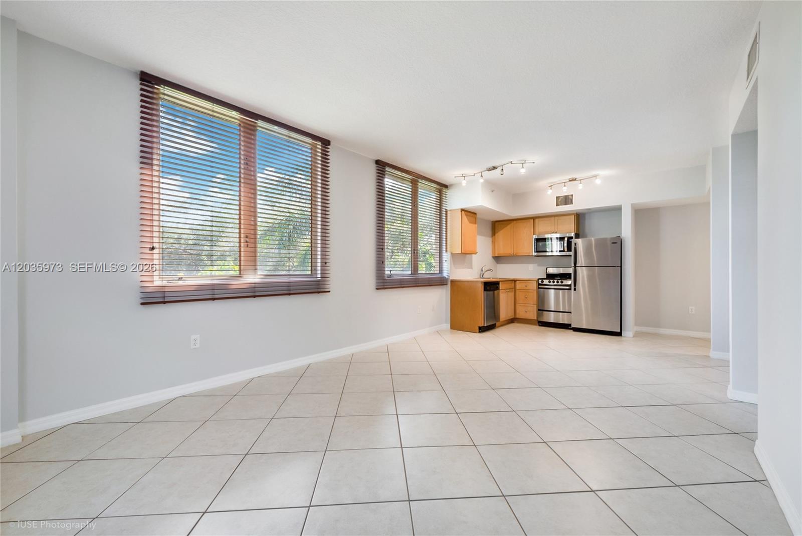 An open-concept room features light-colored tile flooring, two large windows, and a compact kitchen — 2630 SW 28th St # 53, Miami FL 33133, MIAMI, FL