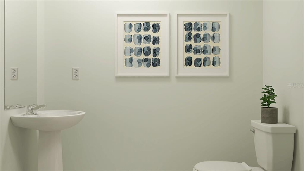 A powder room features a pedestal sink, a toilet, and two framed abstract art prints — 1531 WILLOW GARDEN LOOP, EUSTIS, FL