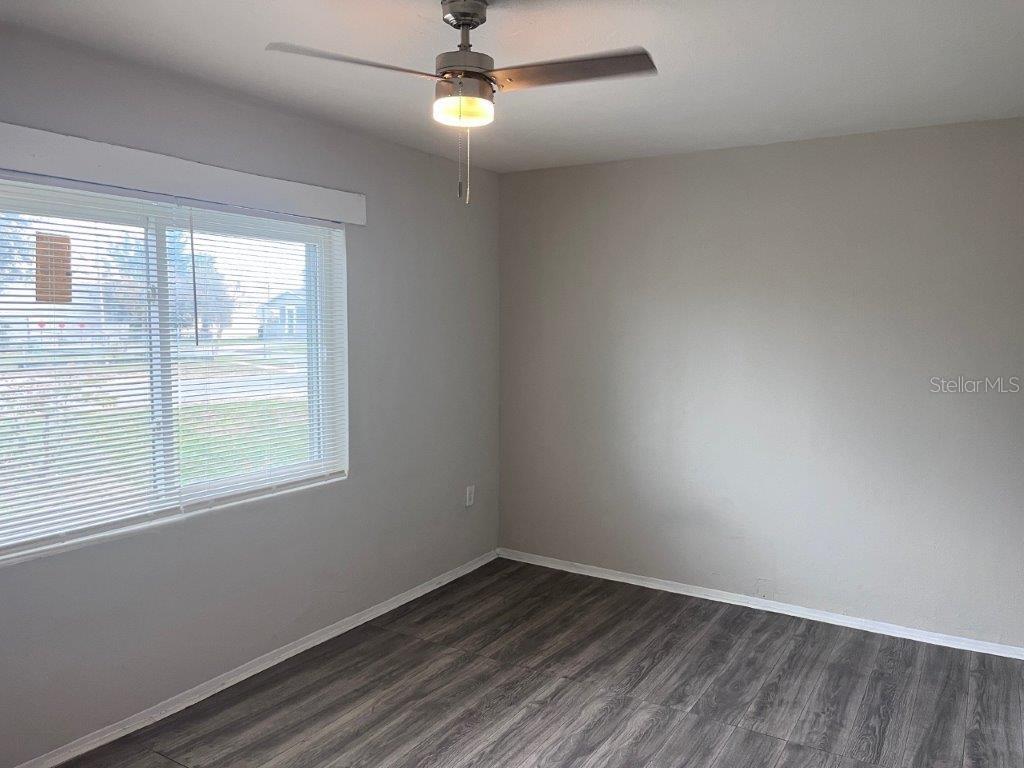 An empty bedroom features light gray walls, dark wood-look flooring, and a ceiling fan — 1040 AVONDALE AVENUE, ORLANDO, FL