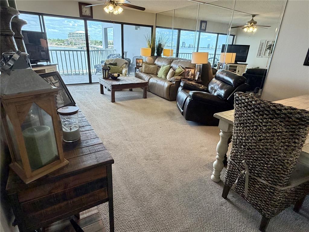 A living room features beige carpet, a leather sofa, a recliner, and a balcony view — 2 ADALIA AVENUE UNIT 405, TAMPA, FL