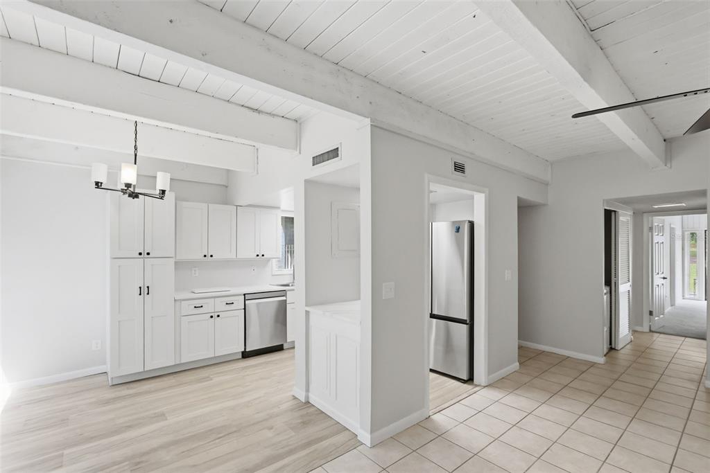 A kitchen with white cabinets, stainless steel appliances, and exposed wood ceiling beams — 100 FAIRWAY DRIVE UNIT 100, LONGWOOD, FL