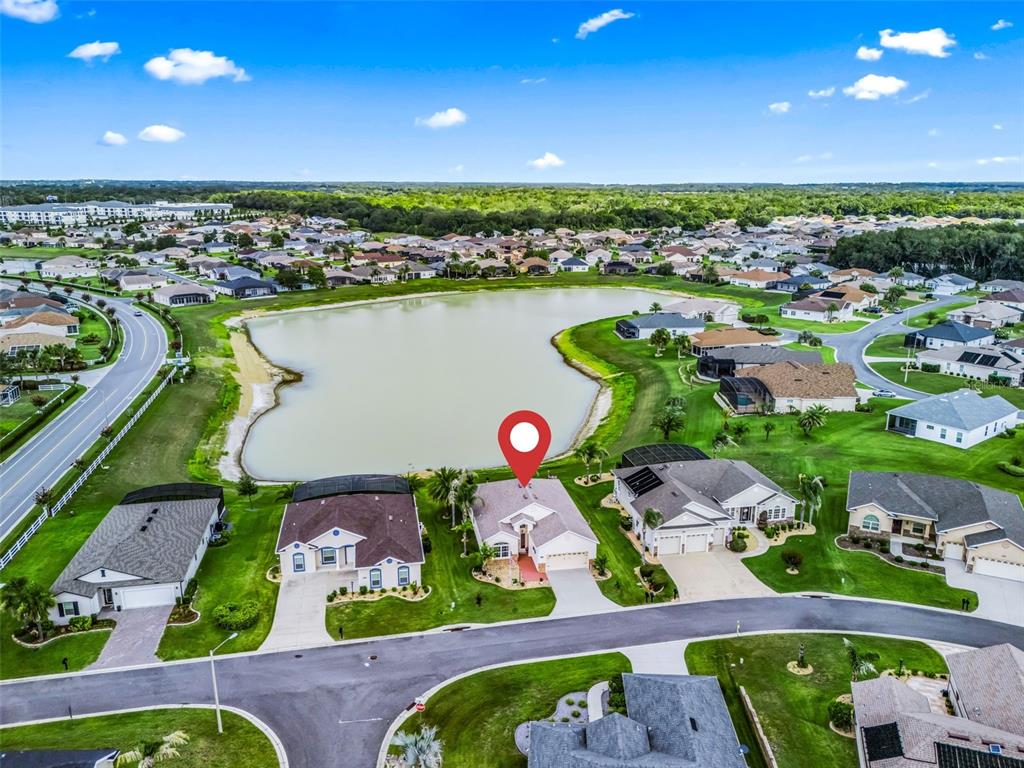 An aerial view shows a suburban house with a red location pin near a lake — 11227 SE 172ND PLACE, SUMMERFIELD, FL