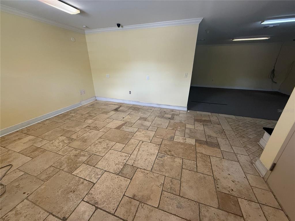 An interior room features light yellow walls, a stone tile floor, and recessed lighting — 4344 SE 95TH STREET UNIT 2, OCALA, FL
