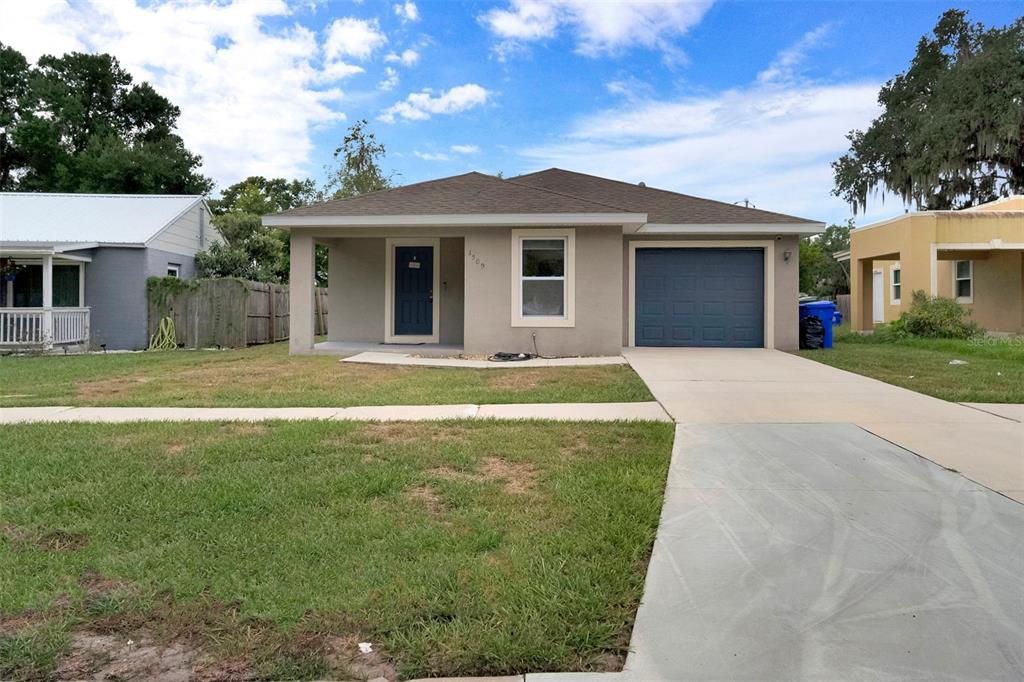 An open-concept living area features white walls, tile flooring, and a wooden kitchen island — 1509 E ELM ROAD, LAKELAND, FL