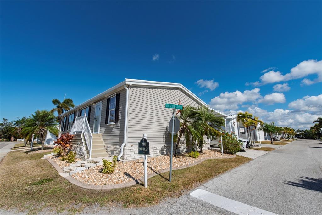 A light gray manufactured home sits on a corner lot with a gravel yard — 1 DEN HELDER AVENUE, PUNTA GORDA, FL