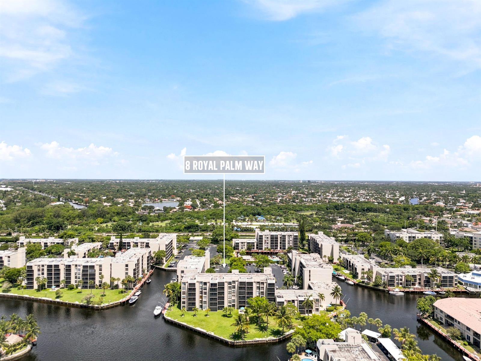 An aerial view shows a multi-story apartment complex surrounded by water and lush landscaping — 8 Royal Palm Way # 3020, Boca Raton FL 33432, BOCA RATON, FL
