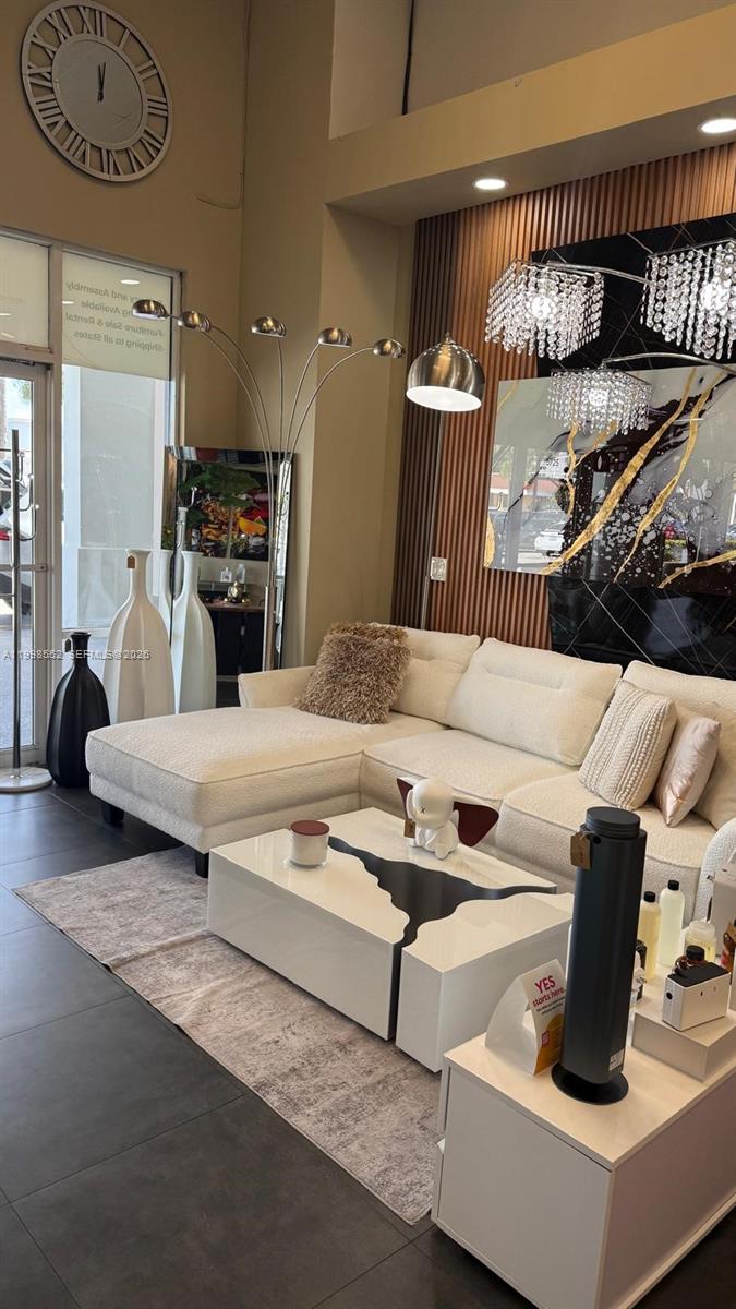A modern living room features a white sectional sofa, a coffee table, and decorative lighting — 5725 NW 7th St, Miami FL 33126, MIAMI, FL
