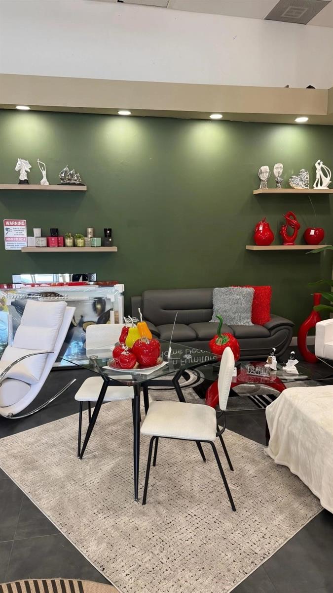 A room features a dining set, a gray sofa, and shelves displaying decorative items — 5725 NW 7th St, Miami FL 33126, MIAMI, FL