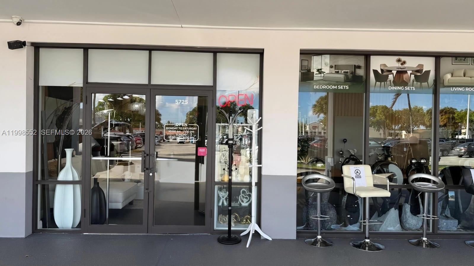 The exterior of a furniture store features glass doors and windows displaying various home furnishings — 5725 NW 7th St, Miami FL 33126, MIAMI, FL